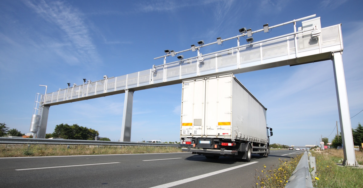 LKW fährt unter Mautbrücke auf Autobahn hindurch